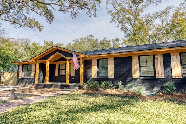 single story home with brick siding, a porch, and a front lawn