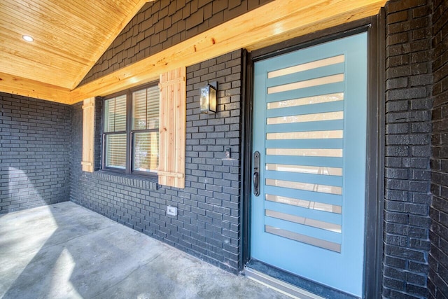 property entrance featuring brick siding and covered porch