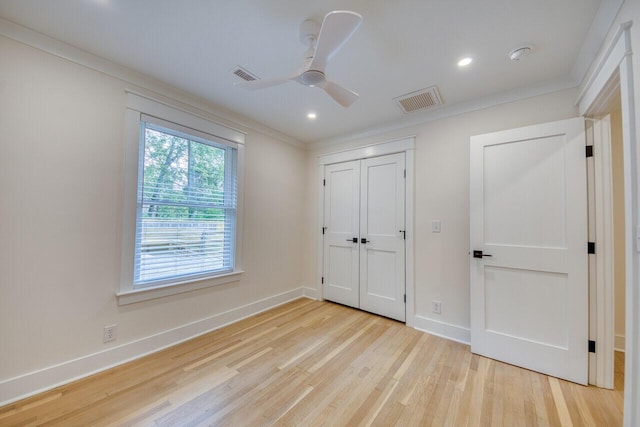 unfurnished bedroom with light wood-type flooring, visible vents, and ornamental molding