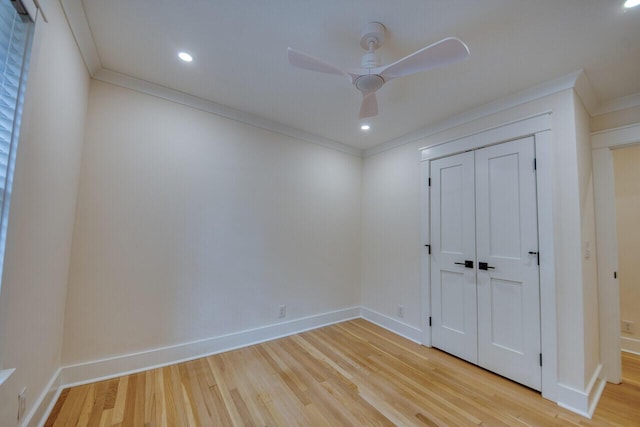 unfurnished bedroom featuring a closet, light wood-type flooring, crown molding, and baseboards