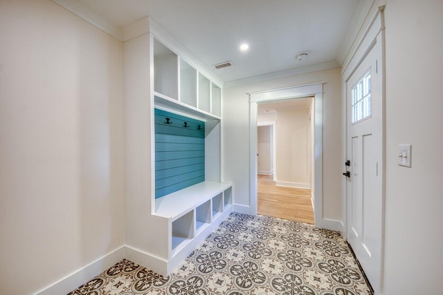 mudroom featuring tile patterned floors, visible vents, baseboards, and ornamental molding