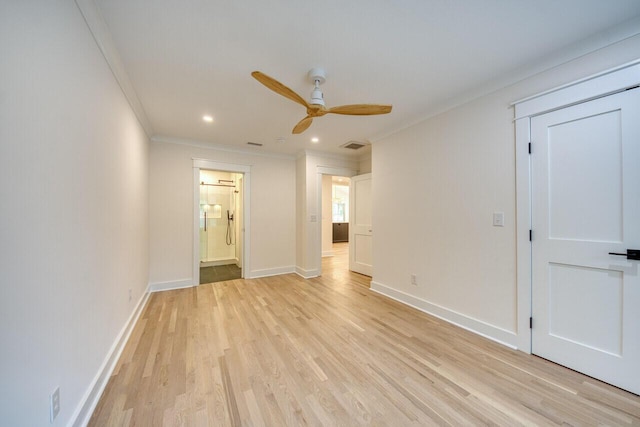 spare room with light wood-style flooring, baseboards, ceiling fan, and crown molding