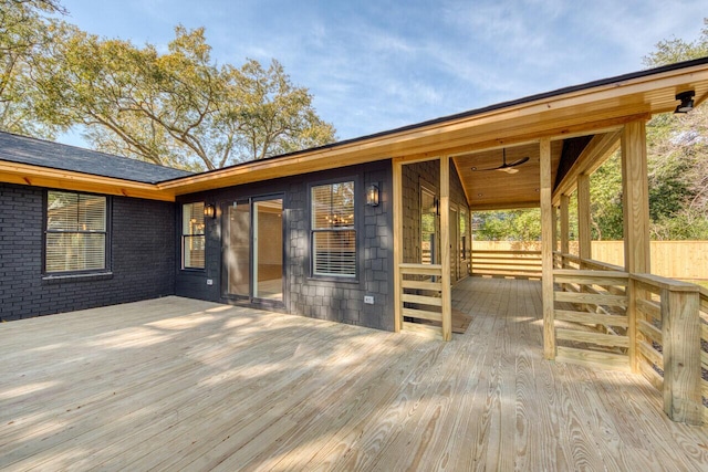 wooden deck with a ceiling fan and fence