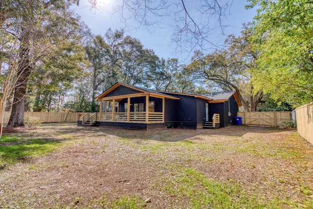 rear view of property featuring a fenced backyard and a gate