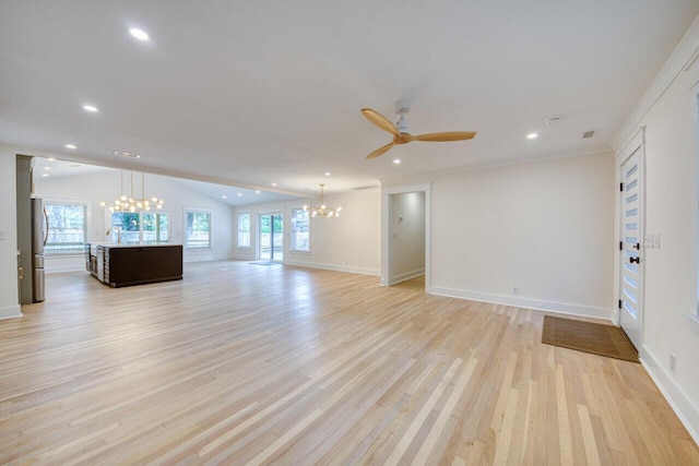 unfurnished living room featuring light wood finished floors, plenty of natural light, ceiling fan with notable chandelier, and lofted ceiling