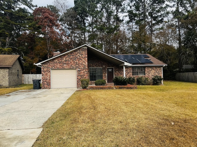 ranch-style home featuring a front lawn, a garage, and solar panels