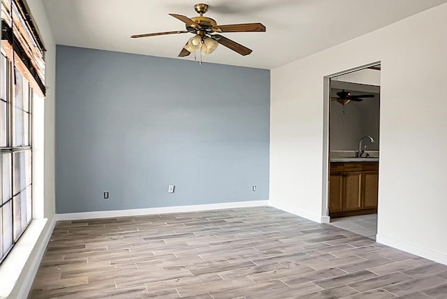 spare room featuring ceiling fan, light wood-type flooring, and sink