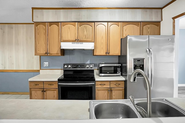 kitchen featuring a textured ceiling, stainless steel appliances, and sink