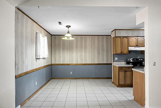 kitchen featuring ornamental molding, light tile patterned floors, decorative light fixtures, black electric range oven, and wood walls