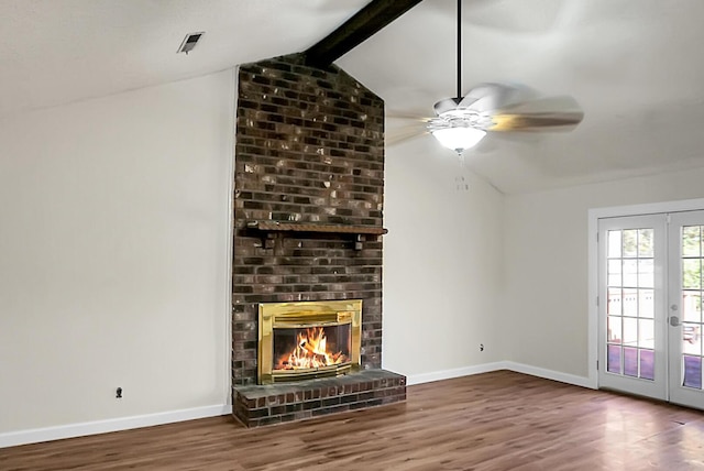 unfurnished living room with ceiling fan, french doors, vaulted ceiling with beams, dark hardwood / wood-style flooring, and a fireplace