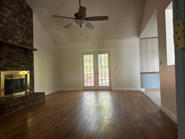 unfurnished living room featuring ceiling fan, french doors, wood-type flooring, lofted ceiling, and a fireplace