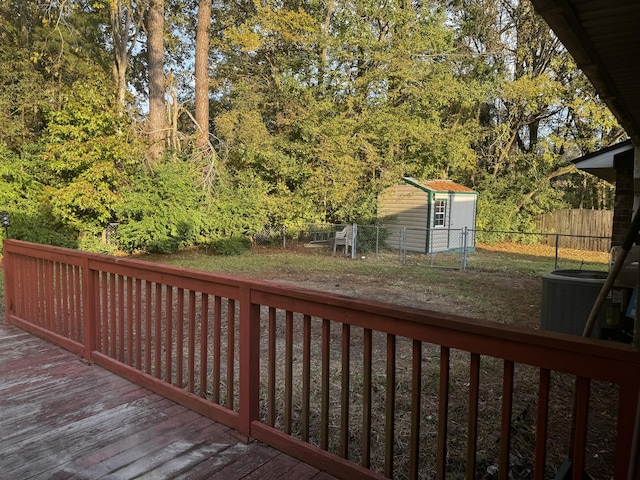 deck featuring central AC unit and a storage shed