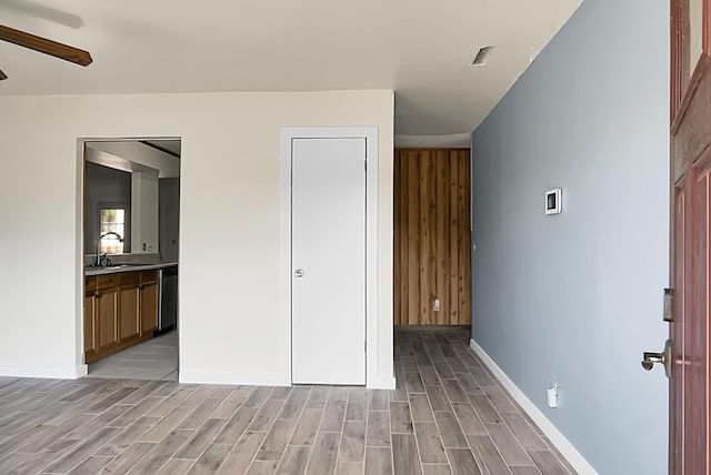 unfurnished bedroom with light hardwood / wood-style floors, ensuite bath, ceiling fan, and sink