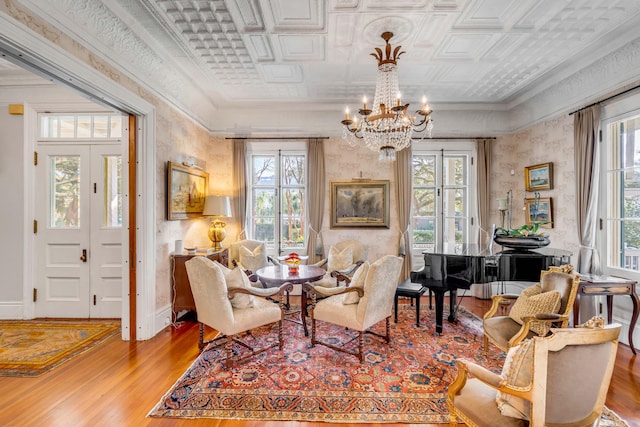 sitting room with an inviting chandelier, crown molding, plenty of natural light, and light hardwood / wood-style floors