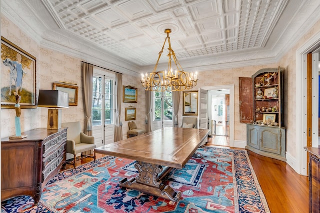 dining area featuring an inviting chandelier, ornamental molding, and light hardwood / wood-style floors