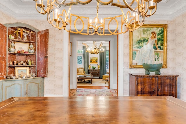 unfurnished dining area featuring crown molding, an inviting chandelier, and light hardwood / wood-style floors