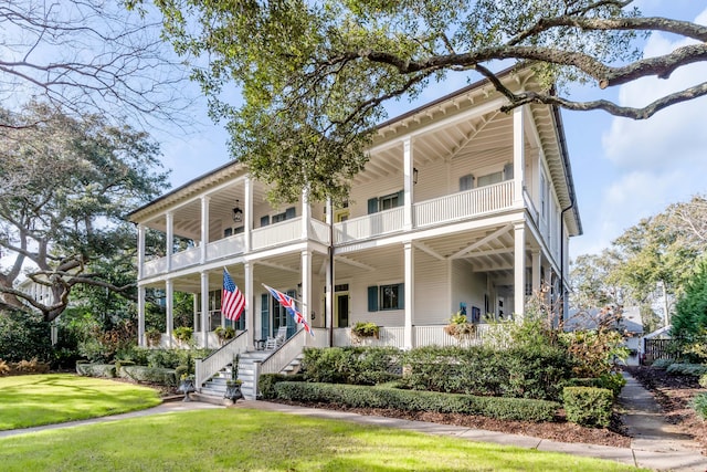 view of front of home with a balcony, a porch, and a front yard