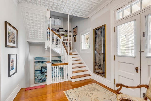 foyer with hardwood / wood-style flooring and ornamental molding