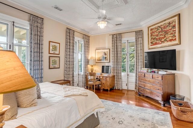 bedroom with crown molding and hardwood / wood-style floors