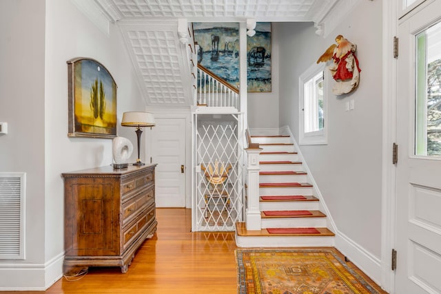 staircase featuring hardwood / wood-style flooring and ornamental molding