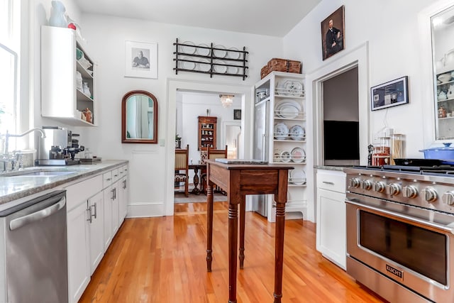 kitchen featuring sink, white cabinetry, stainless steel appliances, and light hardwood / wood-style floors