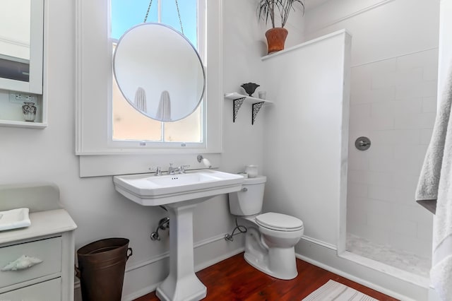 bathroom with hardwood / wood-style floors, a shower with curtain, and toilet