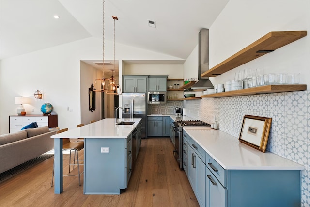 kitchen with lofted ceiling, exhaust hood, a kitchen breakfast bar, tasteful backsplash, and stainless steel appliances