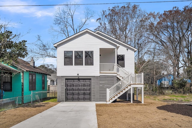 view of front facade with a garage, fence, stairs, driveway, and a front lawn