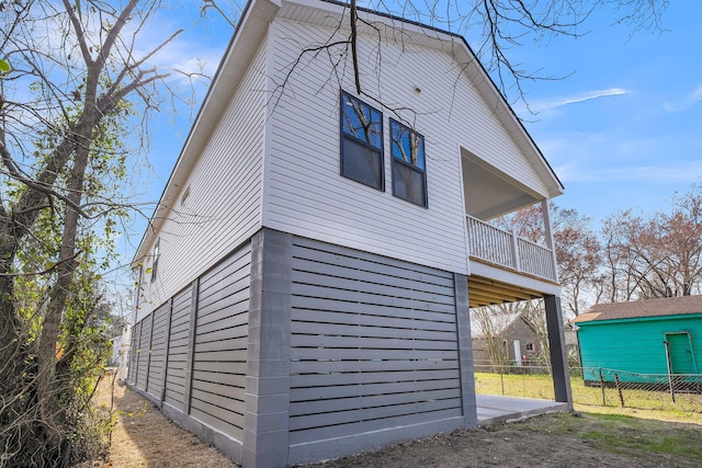 view of home's exterior featuring a balcony and fence