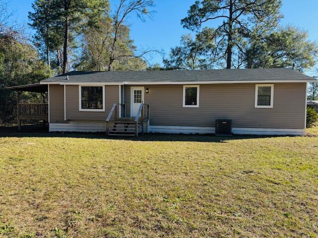 view of front of property featuring central AC unit and a front yard