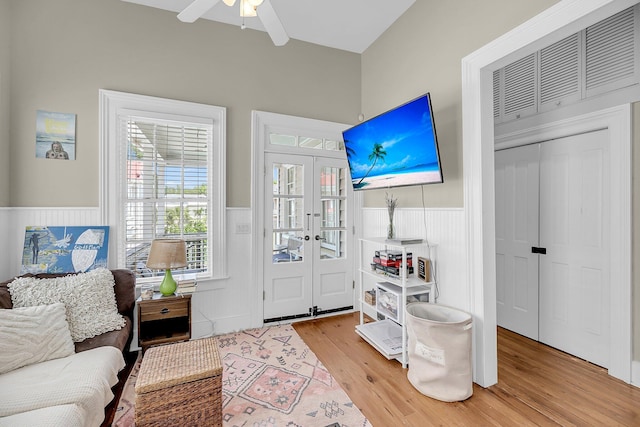 68 Vanderhorst St Unit B, Charleston, SC 29403 - living area with a wainscoted wall, light wood finished floors, a ceiling fan, and french doors