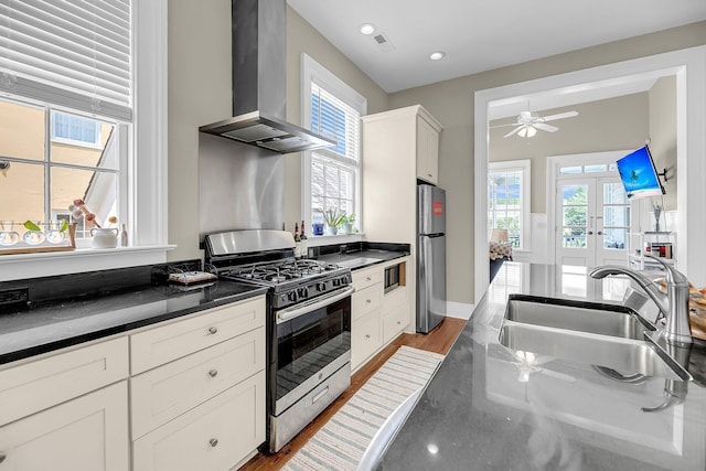 68 Vanderhorst St Unit B, Charleston, SC 29403 - kitchen with wall chimney range hood, appliances with stainless steel finishes, dark countertops, plenty of natural light, and recessed lighting