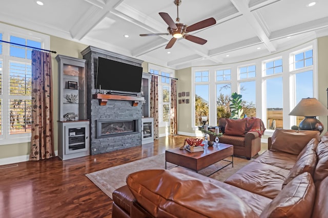 living room with coffered ceiling, wood-type flooring, beamed ceiling, ceiling fan, and a fireplace