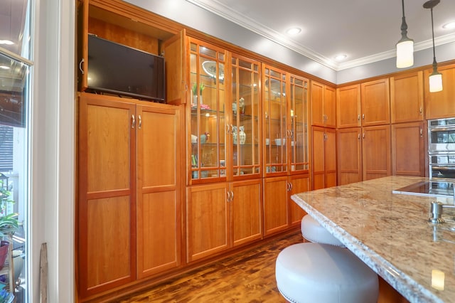 kitchen featuring dark hardwood / wood-style flooring, hanging light fixtures, crown molding, light stone countertops, and stainless steel double oven