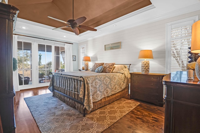 bedroom featuring crown molding, dark hardwood / wood-style floors, access to exterior, and a raised ceiling