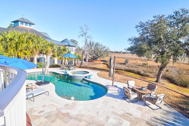 view of pool with a patio and an in ground hot tub