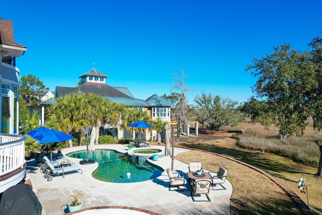 view of pool featuring a patio and an in ground hot tub