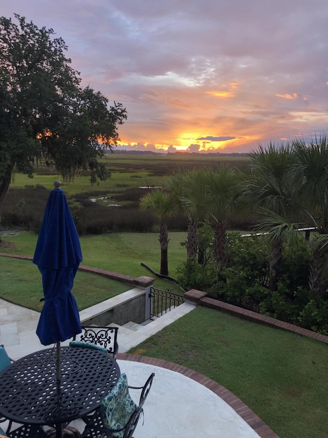 yard at dusk featuring a patio