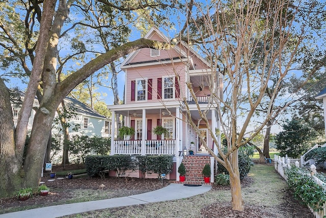 victorian home featuring covered porch and fence