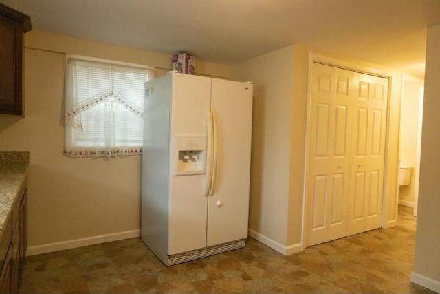 424 Salley Ackerman Dr, Cottageville, SC 29435 - kitchen featuring baseboards, white fridge with ice dispenser, and light countertops