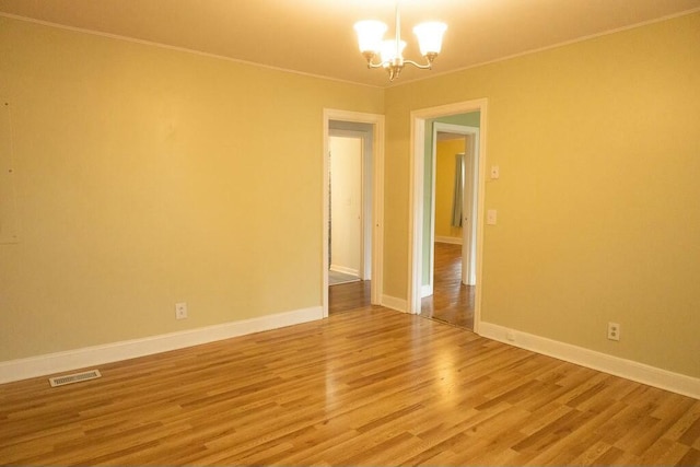 424 Salley Ackerman Dr, Cottageville, SC 29435 - spare room featuring visible vents, light wood-style flooring, an inviting chandelier, crown molding, and baseboards