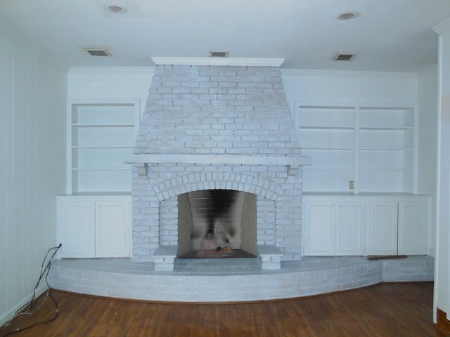 interior details featuring a brick fireplace, built in features, crown molding, wooden walls, and hardwood / wood-style flooring