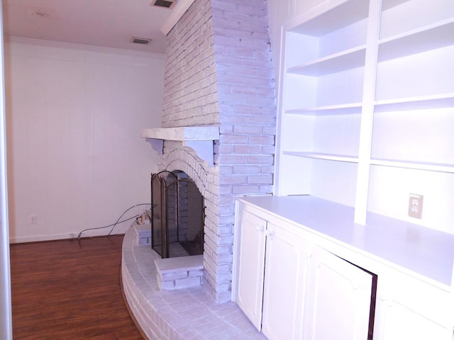 unfurnished living room with ornamental molding, hardwood / wood-style flooring, and a brick fireplace