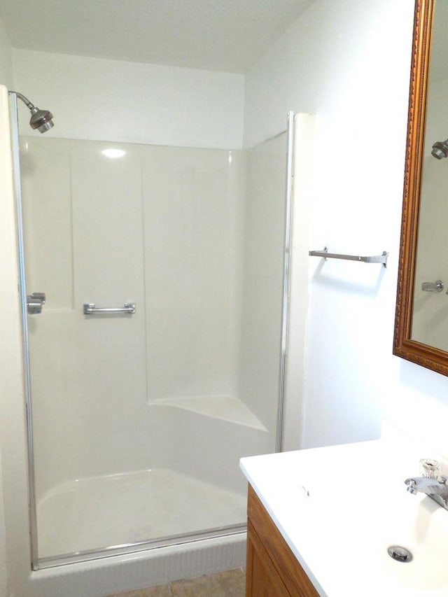 bathroom with walk in shower and vanity