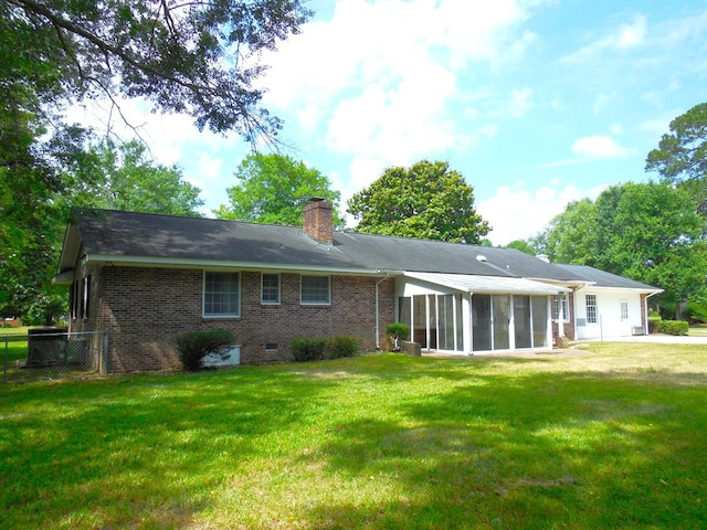 back of house with a yard and a sunroom