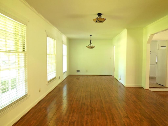 empty room with ornamental molding and dark hardwood / wood-style floors