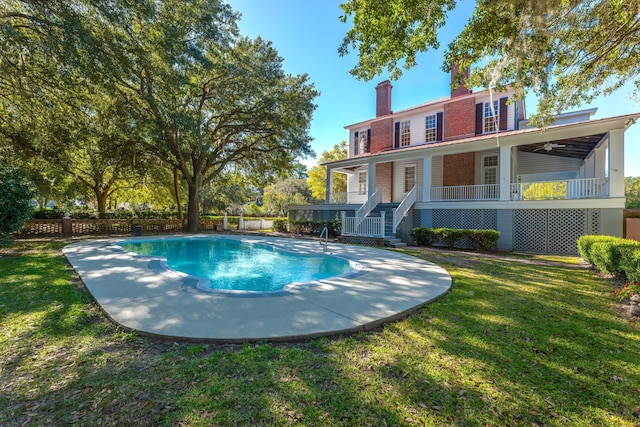 view of pool featuring a lawn