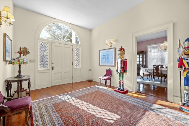 entryway featuring wood-type flooring and a chandelier