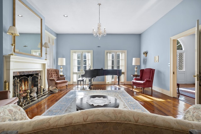 living room featuring a brick fireplace, an inviting chandelier, and hardwood / wood-style flooring