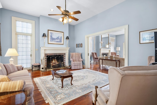 living room featuring wood-type flooring, a fireplace, and ceiling fan